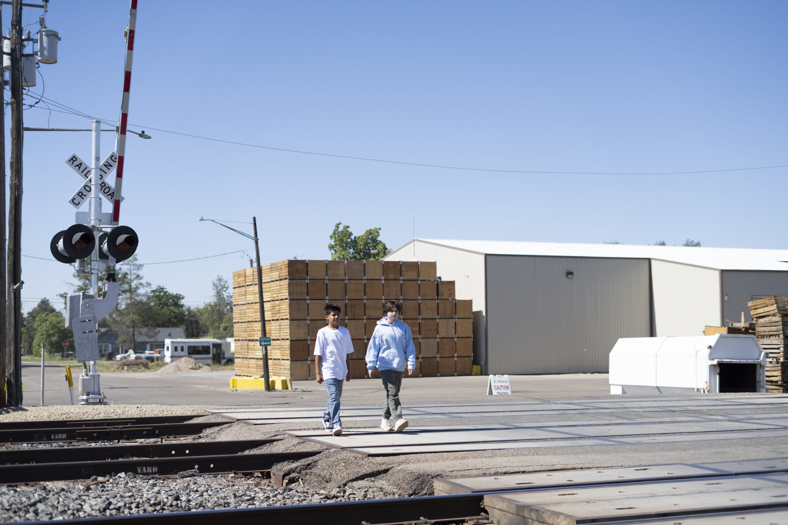 Children crossing street by railroad tracks